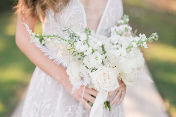 Obraz na płótnie Canvas Bride holding white bouquet 