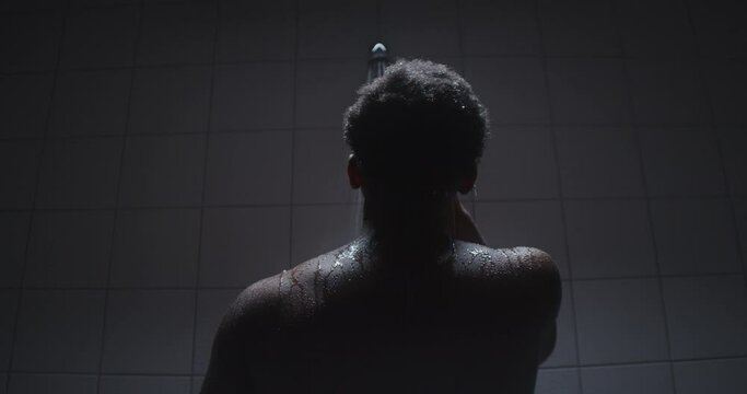 Young black male taking a shower and thinking.
