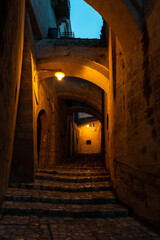 An empty alley with arches above, historic downtown of Matera, Italy