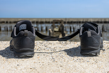 The abandoned shoes at the rim of the ending of a demolished way with sea horizon