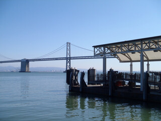 Fototapeta na wymiar Ferry boat dock and Bay Bridge in the distance