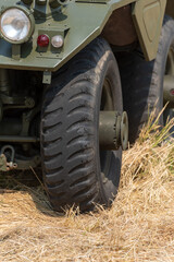 part of a photo of an armored car standing in the meadow behind other military vehicles