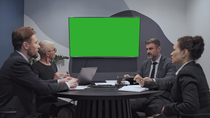 Business consulting team looking at green screen, discussing project, teamwork