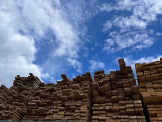 Wooden boards, lumber, industrial wood, timber. Pine wood timber stack of natural rough wooden boards on building site. Industrial timber building materials