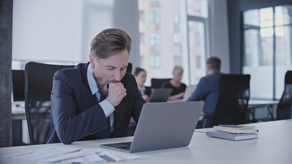 Sleepy manager yawning at computer in office, tired of overworking, burnout