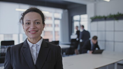 Happy businesswoman looking at camera, employees back to office after lockdown