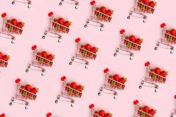 Pattern of fresh red strawberry in shopping cart on pink background. Online shopping and Valentines...