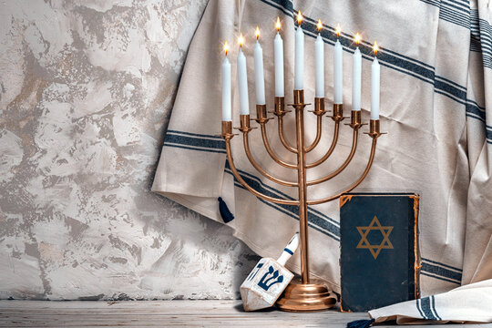 Jewish Hanukkah Menorah, book with star of David, dreidel. Holiday Candle Holder, dreidl, Talmud, or Torah. Nine-arm candlestick. Traditional Hebrew Festival of Lights candelabra. Сopy space