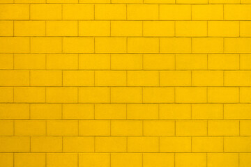 Background with the texture of a brick wall painted in yellow color