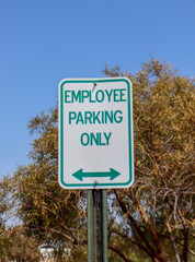 An Employee Parking Only sign with a bidirectional arrow below.
