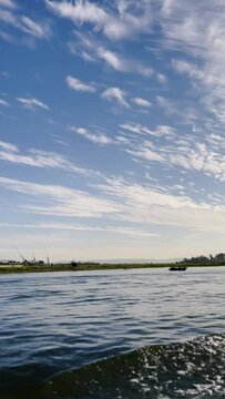 Sailing along the Nile River in Egypt on a yacht. The boat floats on the waves. Beautiful evening landscape on a vertical video.