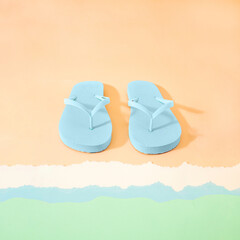 Creative Summer concept of flip flops on the sand on the shore. The baackground of travel with slippers.