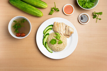Steamed Chicken Rice with raw cucumber, Coriander, salad, sauce and soup served in a dish isolated on wooden background top view