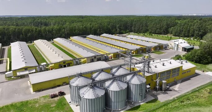aerial view on silos and agro-industrial livestock complex on agro-processing and manufacturing plant with modern granary elevator. chicken farm. rows of chicken coop