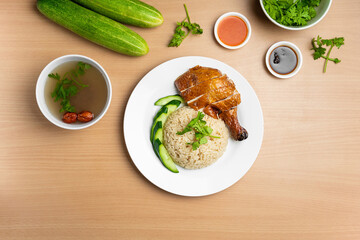 Roasted Chicken rice with raw cucumber, Coriander, salad, sauce and soup served in a dish isolated on wooden background top view
