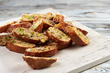 Close up of sweet italian cantuccini cookies with pistachios and almonds on wooden background