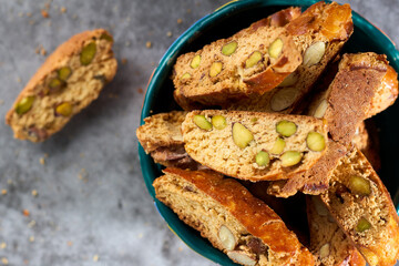 Top view on sweet italian cantuccini cookies with pistachios and almonds in a clay bowl