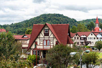 Helen, Georgia Bavarian town cityscape townscape with red roof buildings of German architecture replica with Blue Ridge mountains during Oktoberfest and towers - obrazy, fototapety, plakaty