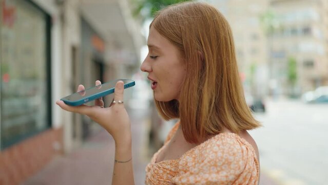 Young redhead woman smiling confident talking on the smartphone at street