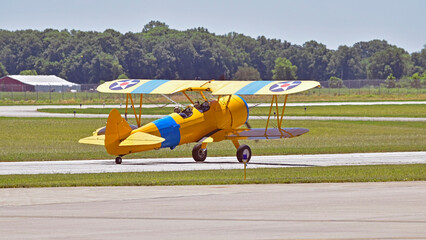 A biplane taxis down the runway in preparation to take off at an airshow. © Don Masten II
