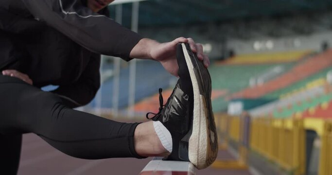 Athlete stretching before training on stadium