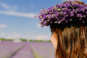 Naklejka premium Woman with wreath of flowers in lavender field