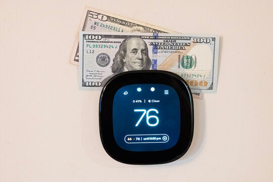 Money on top of digital smart thermometer 