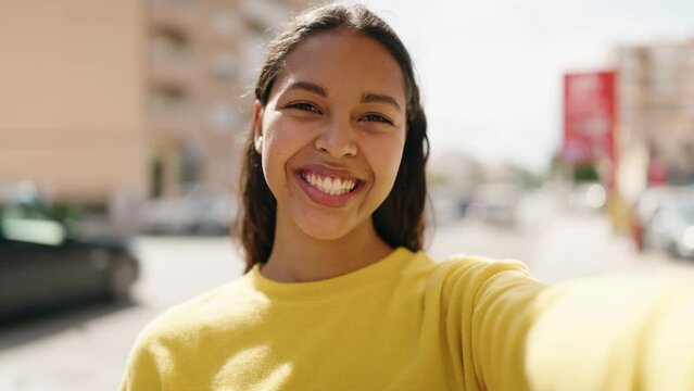 Young african american woman smiling confident making selfie by the camera at street