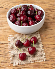 Red cherries on a bowl over wooden table
