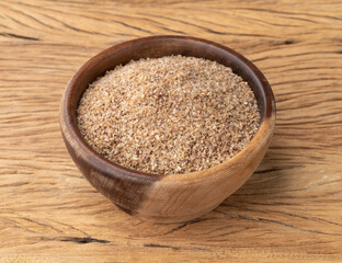 Ground whole wheat in a bowl over wooden table