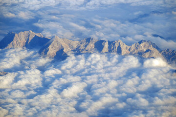 stunning view of the european alps peeking out of the clouds photographed from a plane