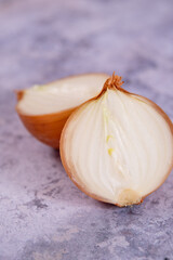 A halved onion on a marble surface background.