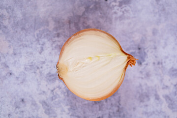 A halved onion on a marble surface background.