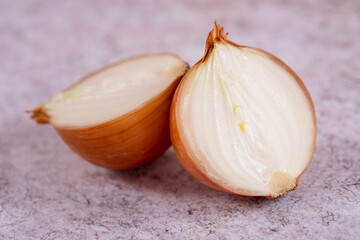 A halved onion on a white stone surface background.