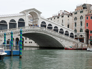 unusual view of the Rialto Bridge in Venice with very few boats and no people during the lockdown in Italy