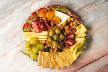 charcuterie board with cheeses, crackers, strawberries, olives, grapes, pastrami, salami, apricot...