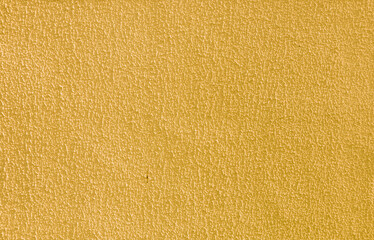 Abstract background of rough yellow plaster.