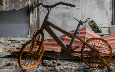 Fototapeta na wymiar Irpin, Ukraine - May 22, 2022: a burned children's bicycle in a house destroyed by Russian troops after the occupation of the city