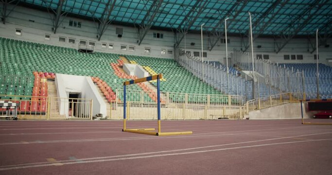 Young runner jumping over hurdle