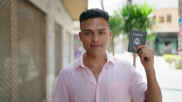 Young latin man smiling confident pointing with finger to passport at street