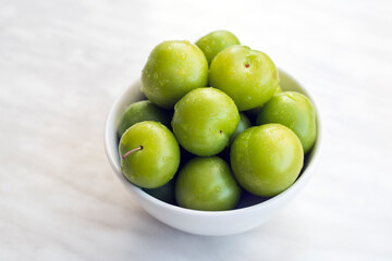 Bowl of fresh and green plums.