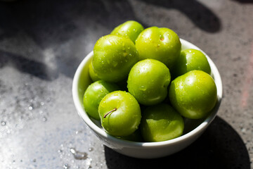 Bowl of fresh and green plums.