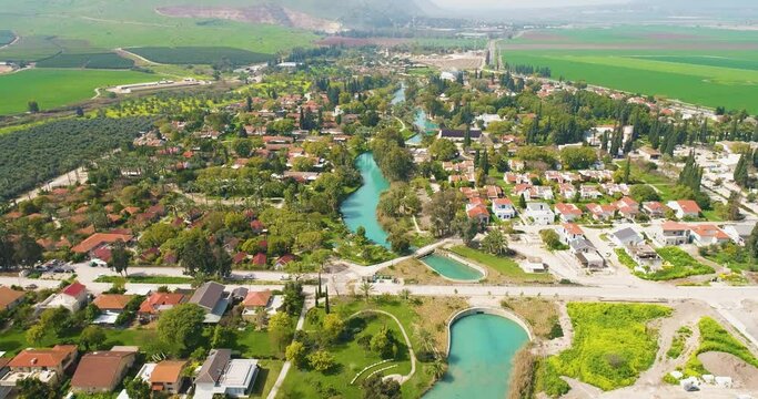 Aerial view of the town with hills in the background and Kibbutzim Stream, Nir David, Northern District, Israel.