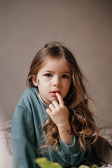 Fototapeta premium Portrait of a 4-year-old girl holding a bouquet of fresh pink tulips posing for a photo with morning light