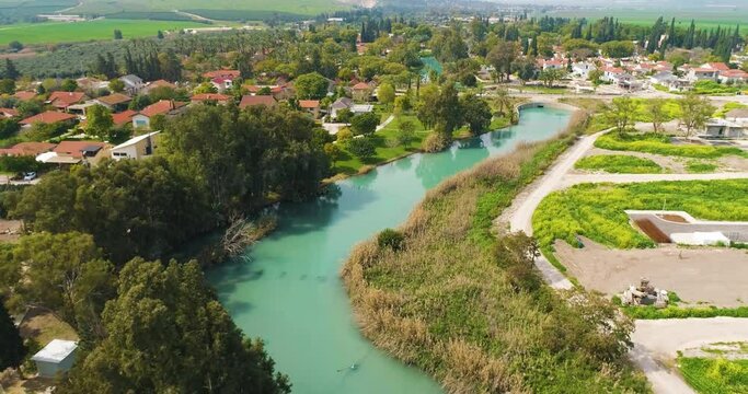 Aerial view of the town with hills in the background and Kibbutzim Stream, Nir David, Northern District, Israel.