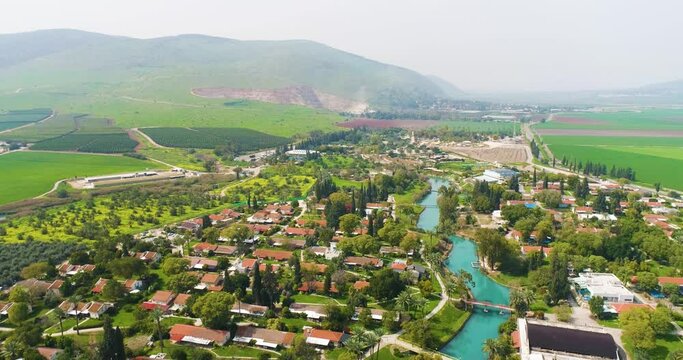 Aerial view of the town with hills in the background and Kibbutzim Stream, Nir David, Northern District, Israel.