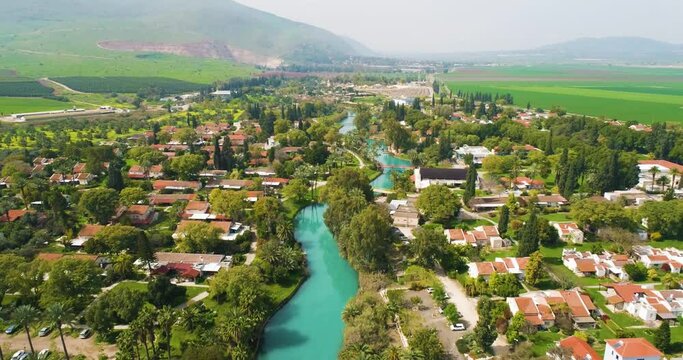 Aerial view of the town with hills in the background and Kibbutzim Stream, Nir David, Northern District, Israel.