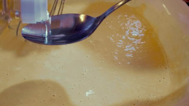 The process of making liquid dough for frying pancakes, dosing with a tablespoon of vegetable oil