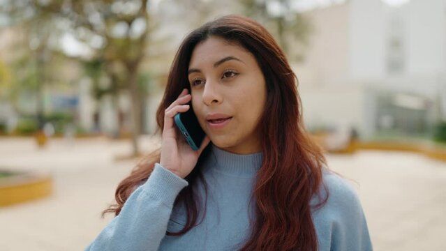 Young hispanic woman smiling confident talking on the smartphone at park