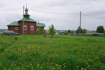 yellow dandelions on a green meadow near the church in the village
